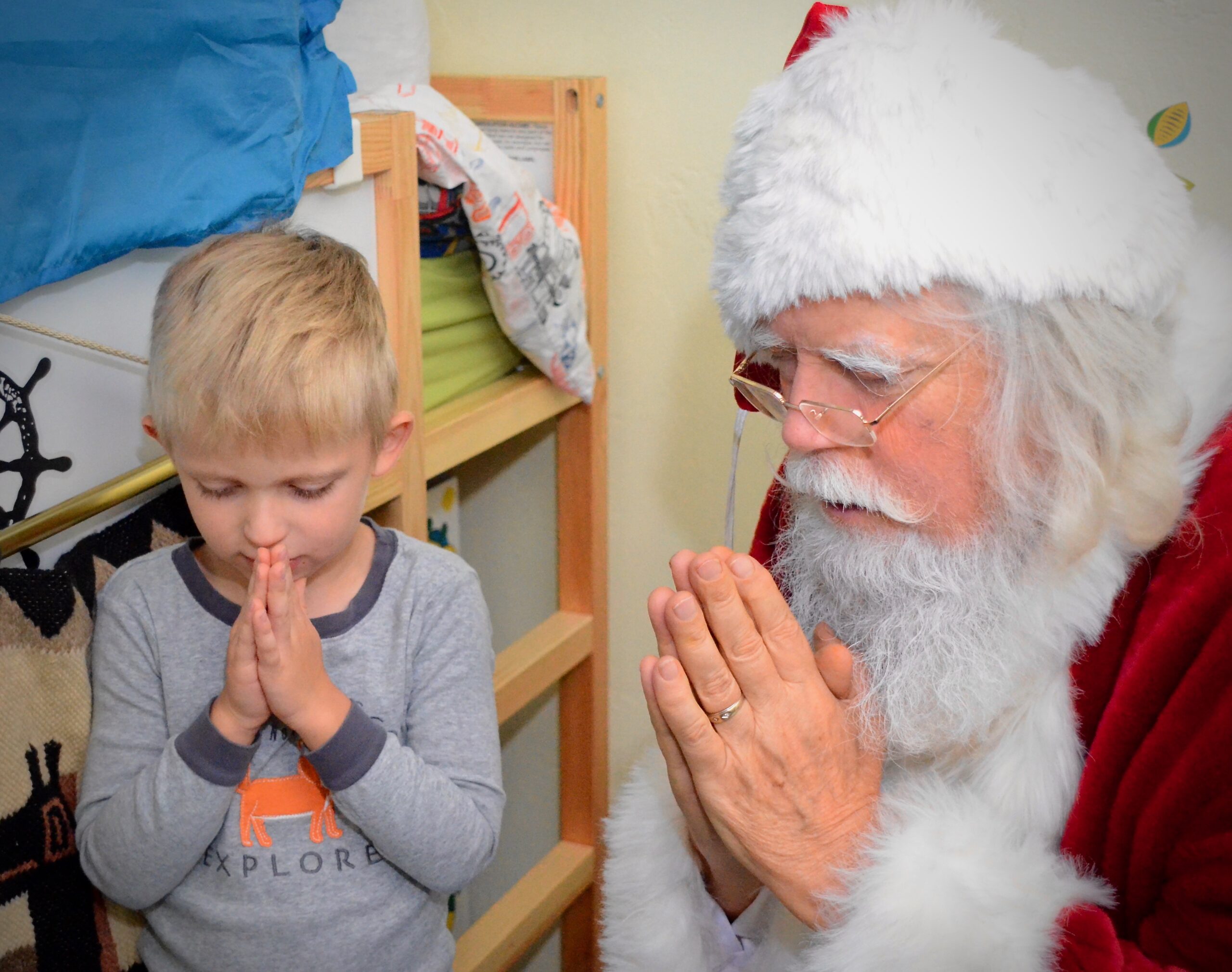 Santa praying with young child
